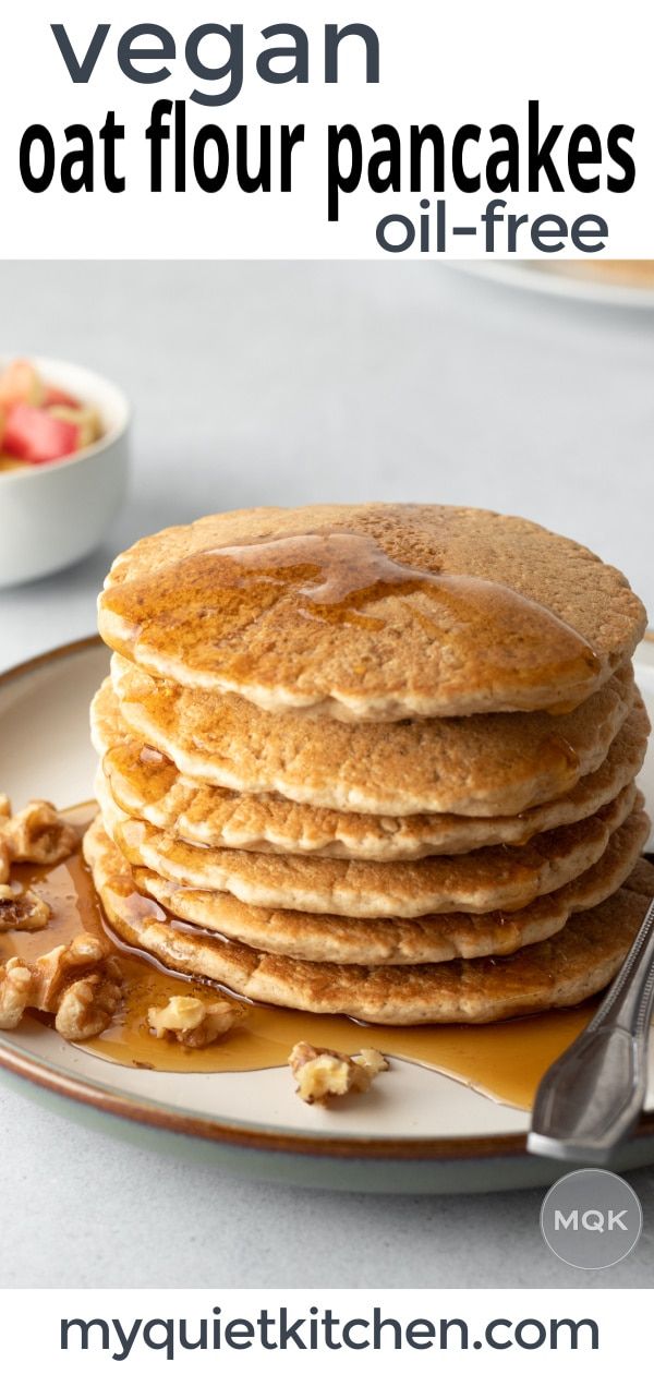 a stack of pancakes sitting on top of a plate next to a bowl of fruit