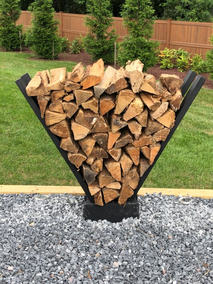 a large pile of wood sitting on top of gravel