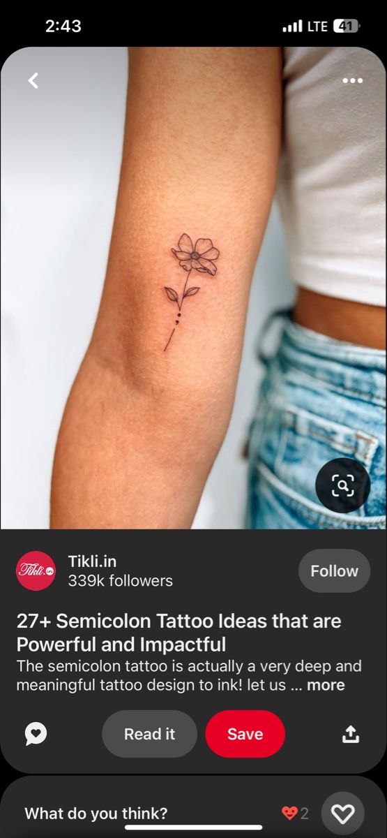 a small flower tattoo on the right arm and shoulder, with an arrow in the middle