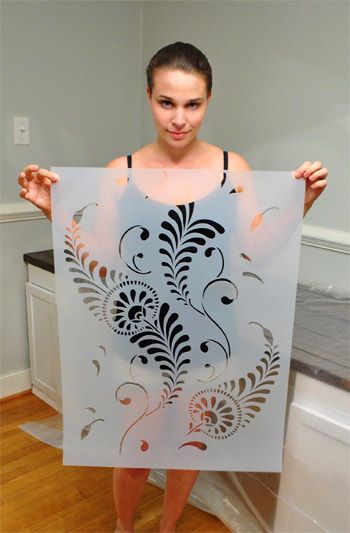 a woman is holding up a cutout in the shape of a flower and leaves