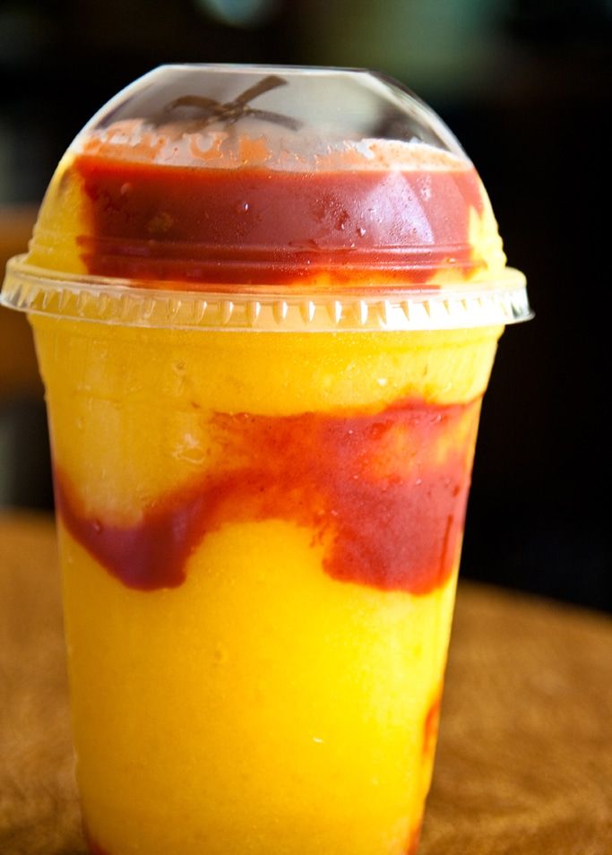 a plastic cup filled with liquid sitting on top of a wooden table