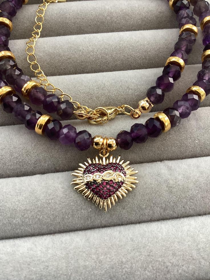 Item details Elevate your jewelry collection with our Sacred Heart amethyst necklace. Embrace the mystical beauty of this 16k Gold Plated pendant featuring Religious Mexican Milagros design and a natural Purple stone. This crystal choker is a stunning tribute to the Heart Of Jesus. Make a statement with this unique piece of Jewellery. I have used faceted rondelle amethyst beads  6 mm, to create this soft purple necklace. Varied shades of purple to create this sparkling Beaded Necklace Sacred Hea Purple Round Beaded Jewelry For Mother's Day, Spiritual Natural Stones Jewelry For Mother's Day, Spiritual Gemstone Beads Jewelry For Valentine's Day, Purple Round Bead Jewelry For Valentine's Day, Purple Round Beads Jewelry For Valentine's Day, Adjustable Gemstone Beads Jewelry For Valentine's Day, Amethyst Birthstone Heart Pendant Jewelry, Valentine's Day Gemstone Beads Jewelry Gift, Valentine's Day Gift Jewelry With Gemstone Beads