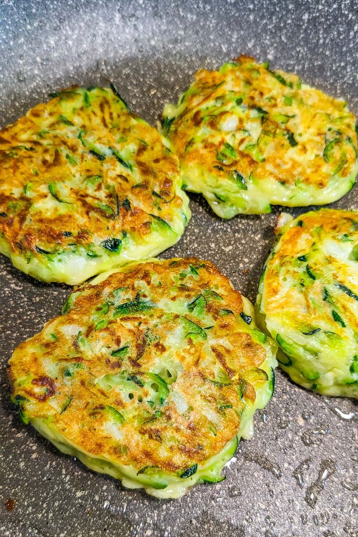 four frittatas sitting on top of a pan covered in broccoli