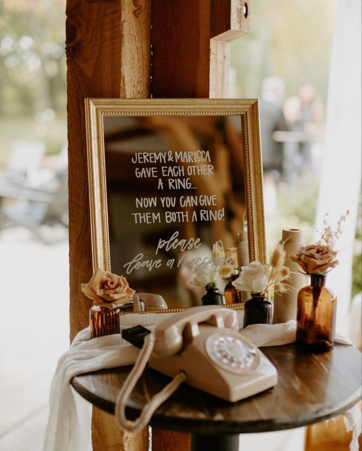 an old fashioned phone sitting on top of a table next to a sign that says, jereme and marina gave each other