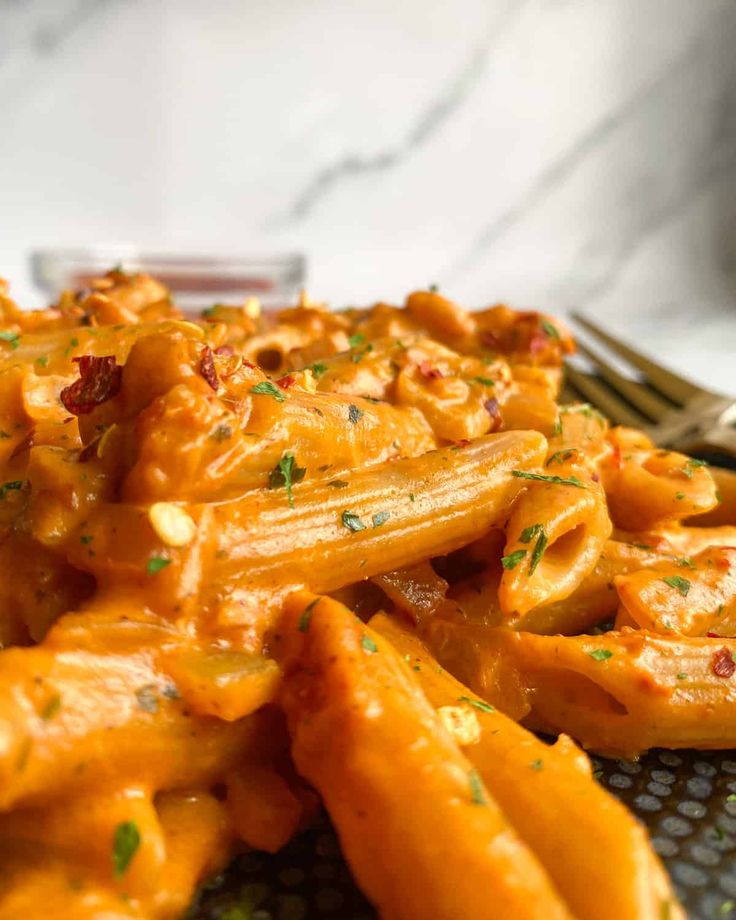 a plate full of pasta with sauce and parmesan cheese