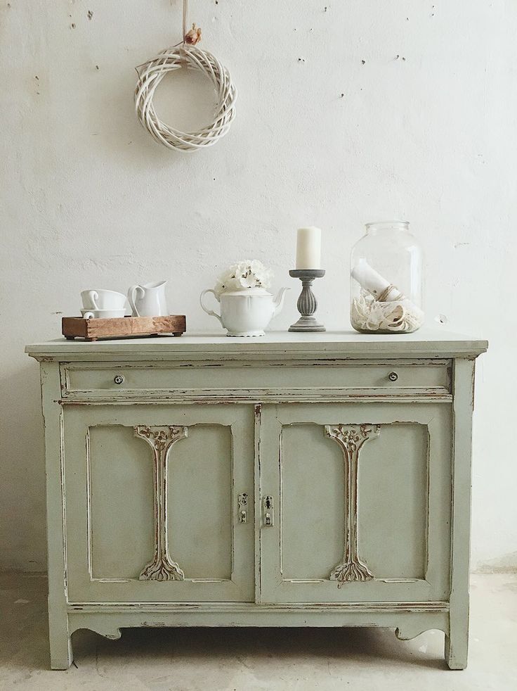 an old dresser is decorated with white flowers and candles