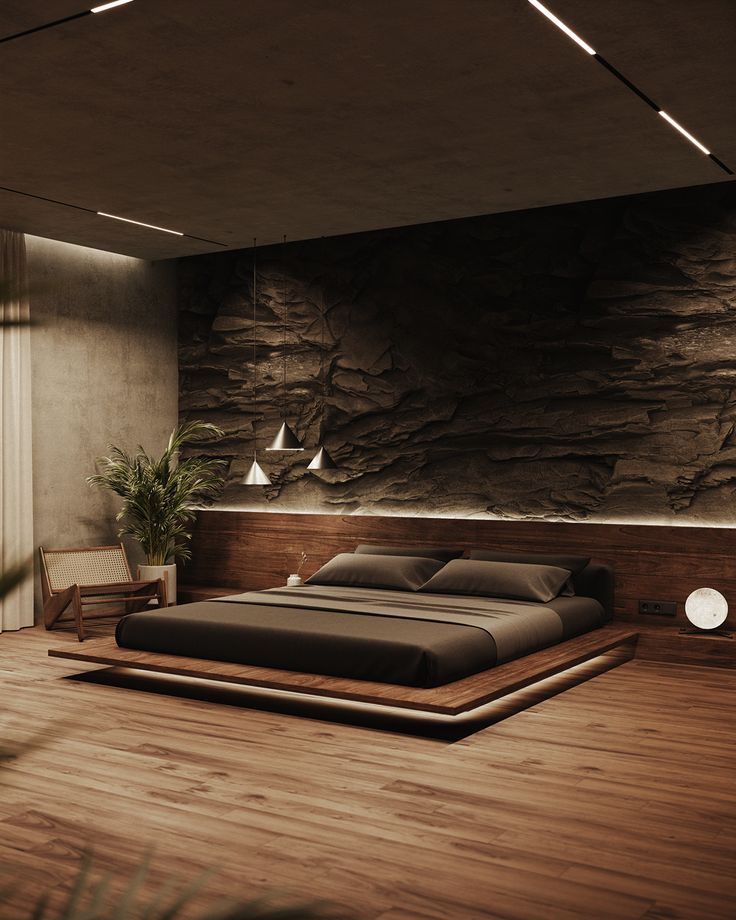 a large bed sitting on top of a wooden floor next to a wall covered in rocks