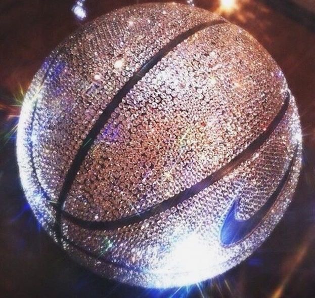 a close up of a basketball ball on a table with lights in the back ground