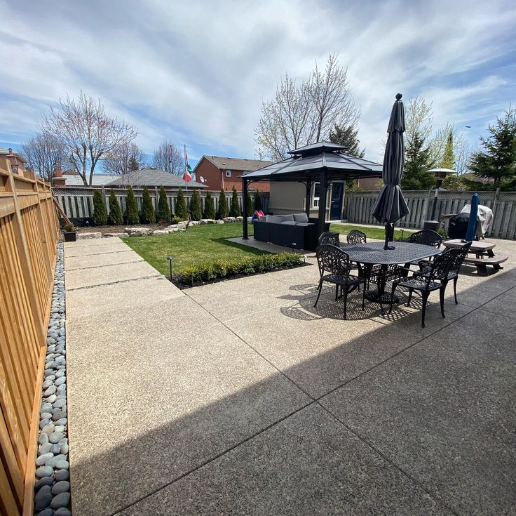 an outdoor patio with table, chairs and umbrella