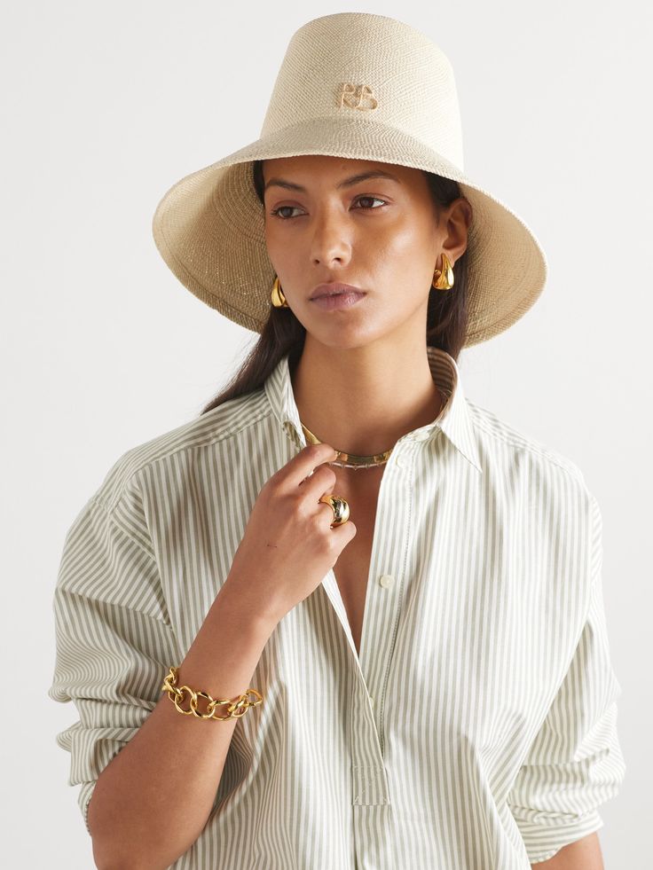 The elongated crown on Ruslan Baginskiy's bucket hat instantly sets it apart from other styles. Hand-woven from natural straw, it has a wide brim and the designer's initials decorating the front. Luxury Toquilla Straw Hat, Designer Wide Brim Beach Hat, Designer Wide Brim Hat For Beach, Designer Wide Brim Hat For The Beach, Spring Straw Bucket Hat, Designer Beige Hat For Summer, Designer Beige Summer Hat, Elegant Woven Straw Hat For Travel, Woven Summer Bucket Hat