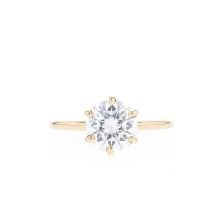 a yellow gold engagement ring with a round brilliant diamond in the center, on a white background