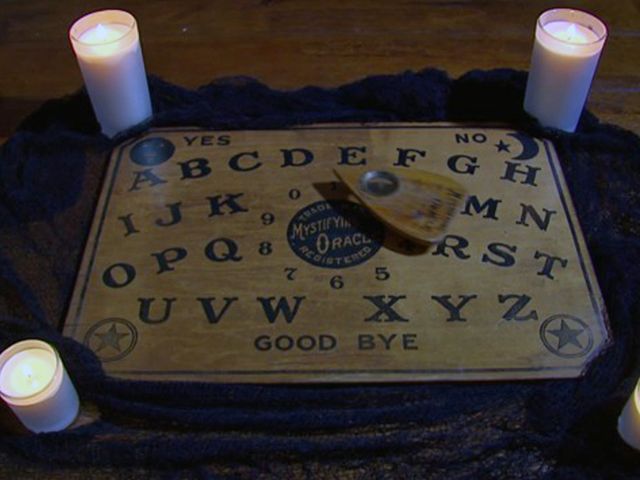 several candles are lit in front of a wooden sign with letters and numbers on it