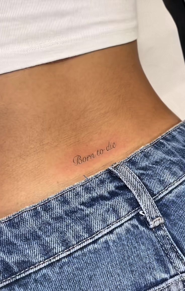 a woman's stomach with the words born to die tattooed on her lower back