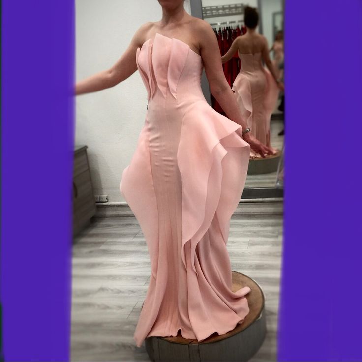 a woman in a pink dress posing for the camera