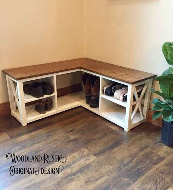 a corner bench with shoe storage underneath it