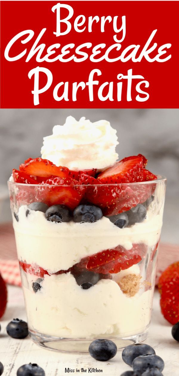 berry cheesecake parfaits in a glass dish with strawberries and blueberries