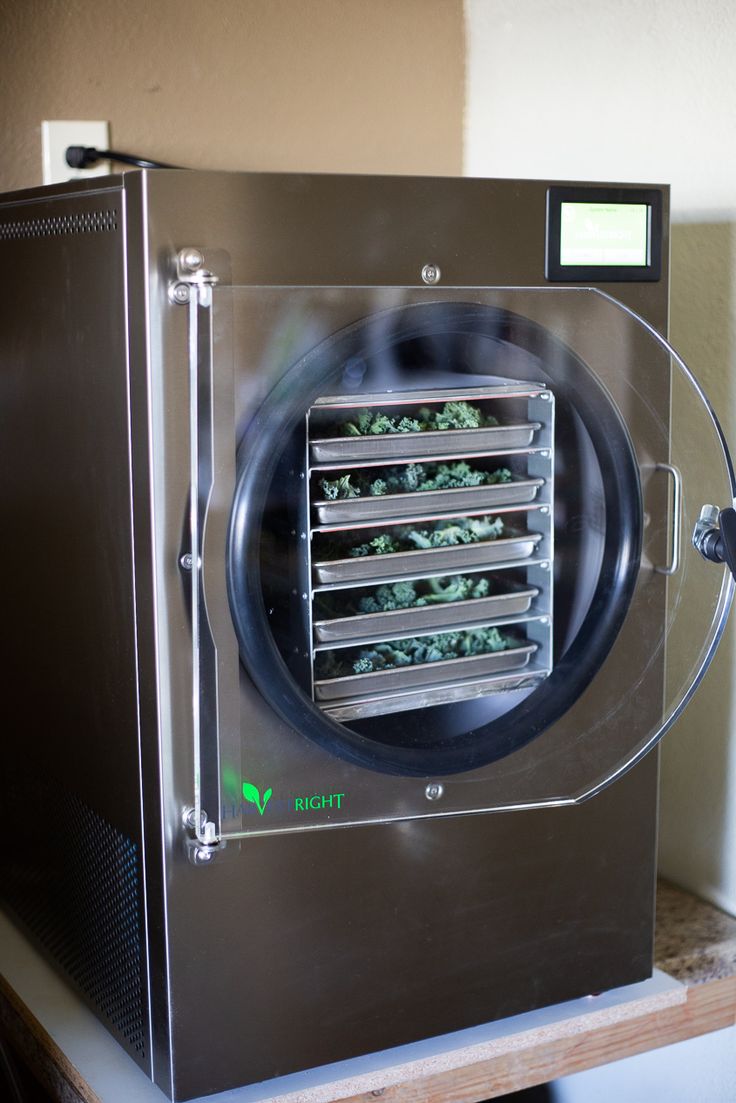 a machine that is sitting on top of a shelf with plants growing inside it and the door open