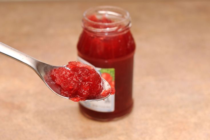 a spoon full of jam on top of a table