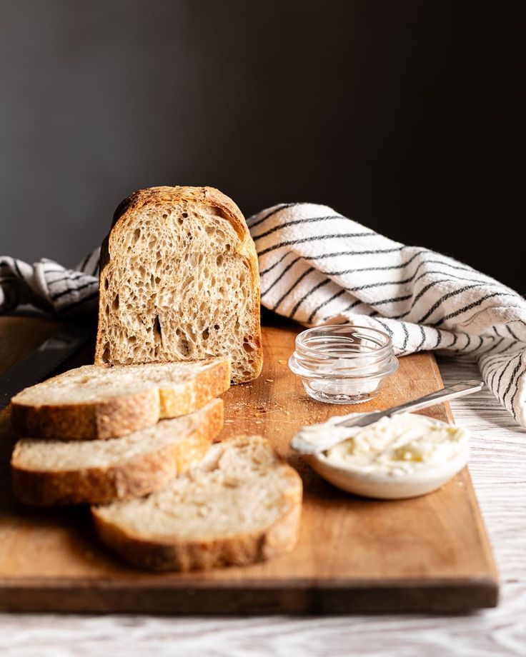 a loaf of bread sitting on top of a wooden cutting board next to some butter