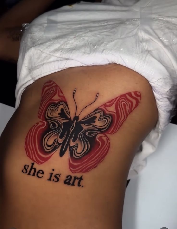 a woman's stomach with a butterfly tattoo on it that says, she is art