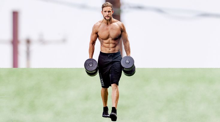 a man running with two dumbs in his hands while wearing black shorts and no shirt