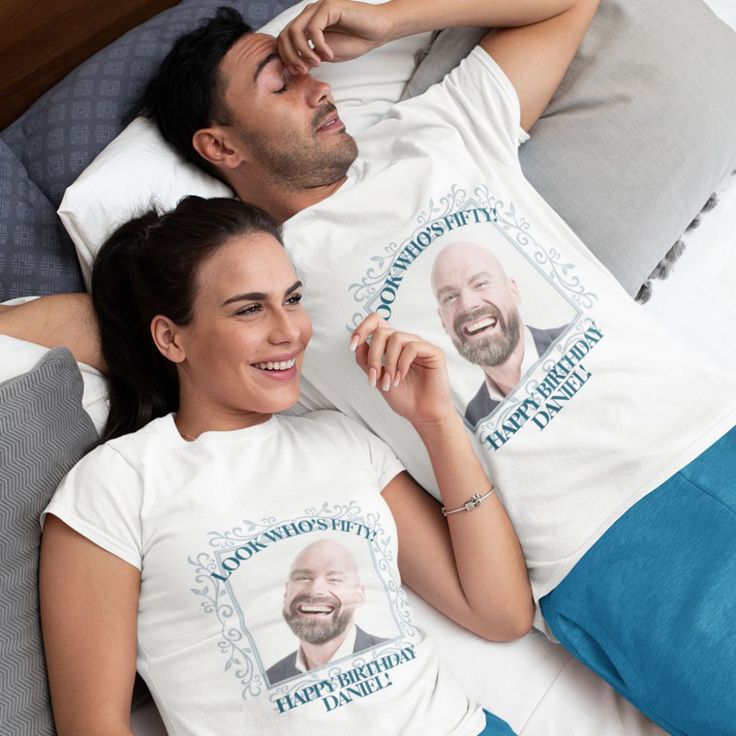 a man and woman laying in bed wearing t - shirts with the same image on them