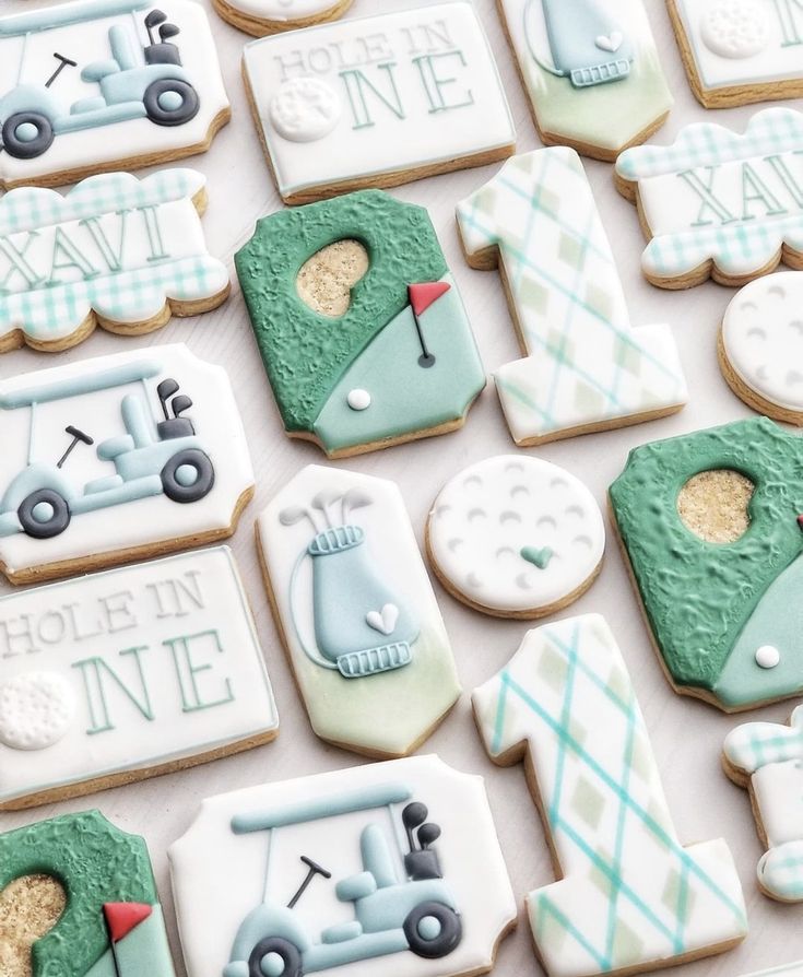 decorated cookies are arranged on a table with golf related items in the shape of men's and women's tees