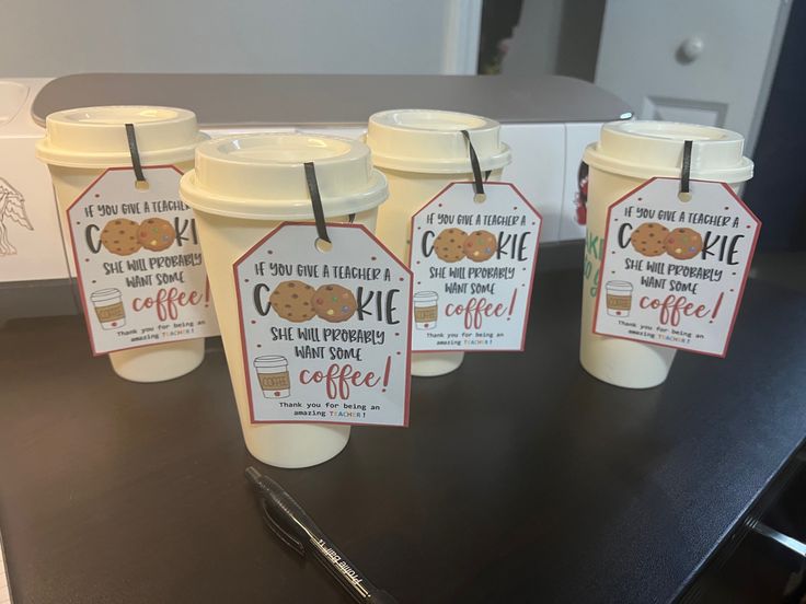 six coffee cups with tags on them sitting on a table