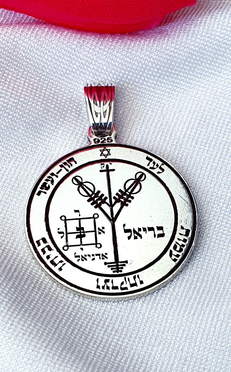 a pendant with an image of the tree of life on it