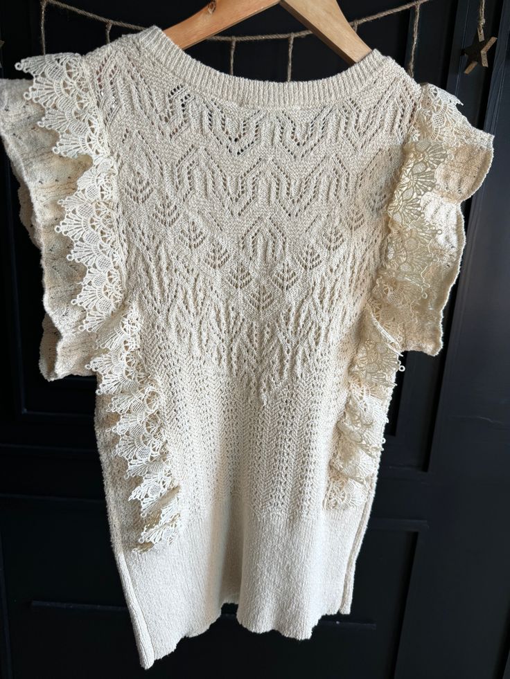 Gussy up your winter wardrobe with this romantic lace-trimmed sweater. The ivory design features ruffles and a delicate crochet lace trim, making for a look that's sure to turn heads. Sleeveless and cozy, you'll love this one-of-a-kind addition to your closet! True to size. Lace Crochet Top With Lace Trim For Layering, Chic Lace Crochet Top With Pointelle Knit, Fitted Cream Sweater With Ruffles, Lace Ruffles Tops For Layering, Lace Tops With Ruffles For Layering, Lace Ruffle Top For Layering, Lace Top With Ruffles For Layering, Cream Fitted Sweater With Ruffles, Fall Lace Top With Ruffles