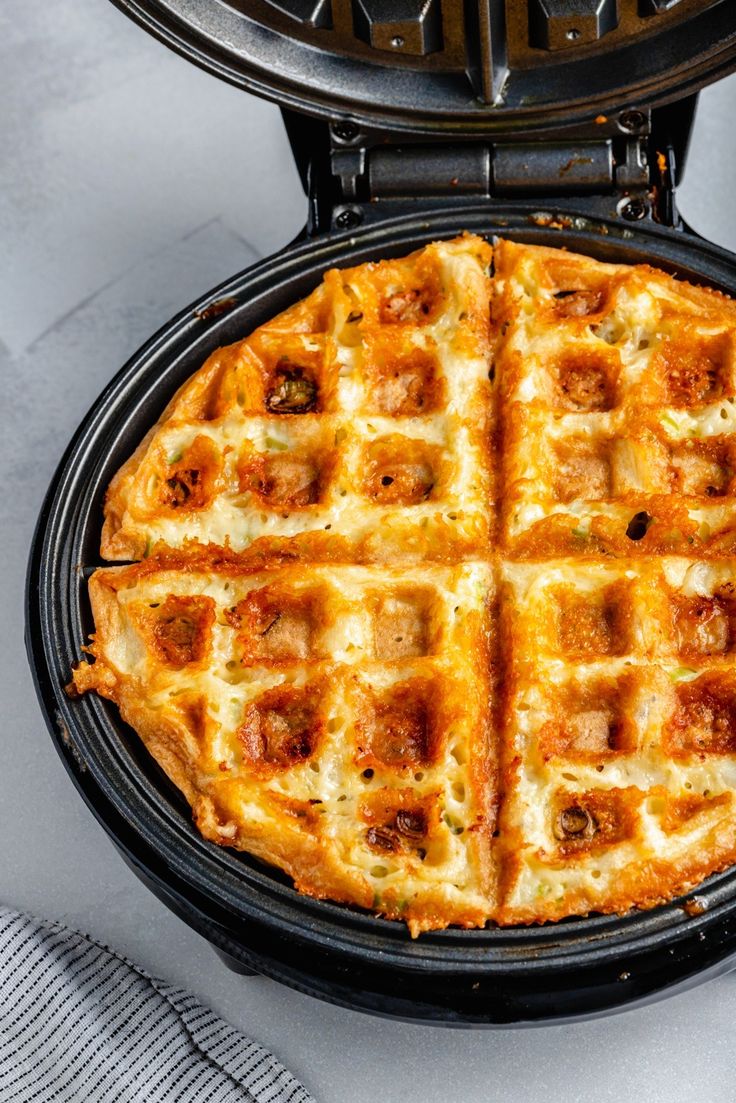 a waffle iron with some food inside of it