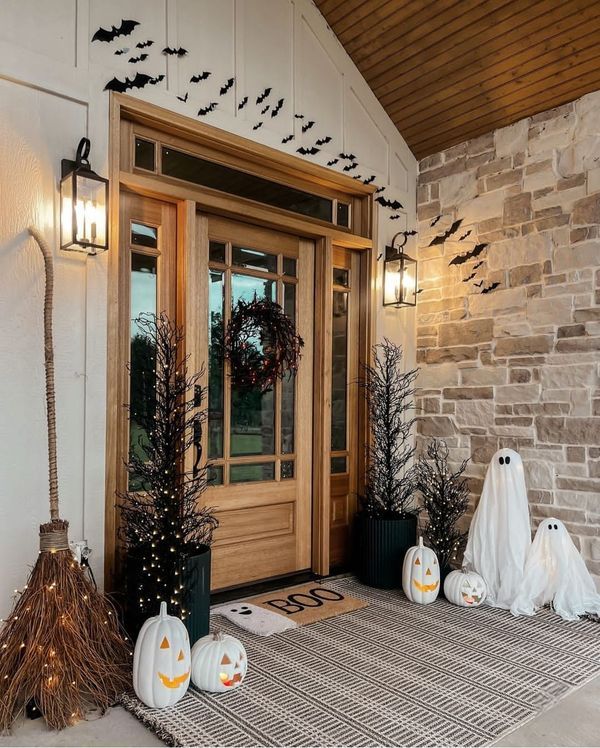 the front door is decorated for halloween with pumpkins and bats