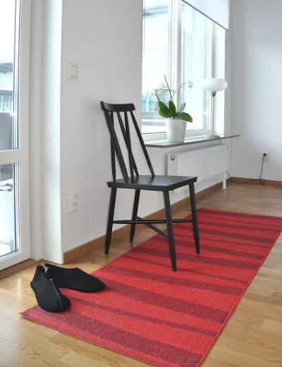 a chair sitting on top of a wooden floor next to a yellow and white rug