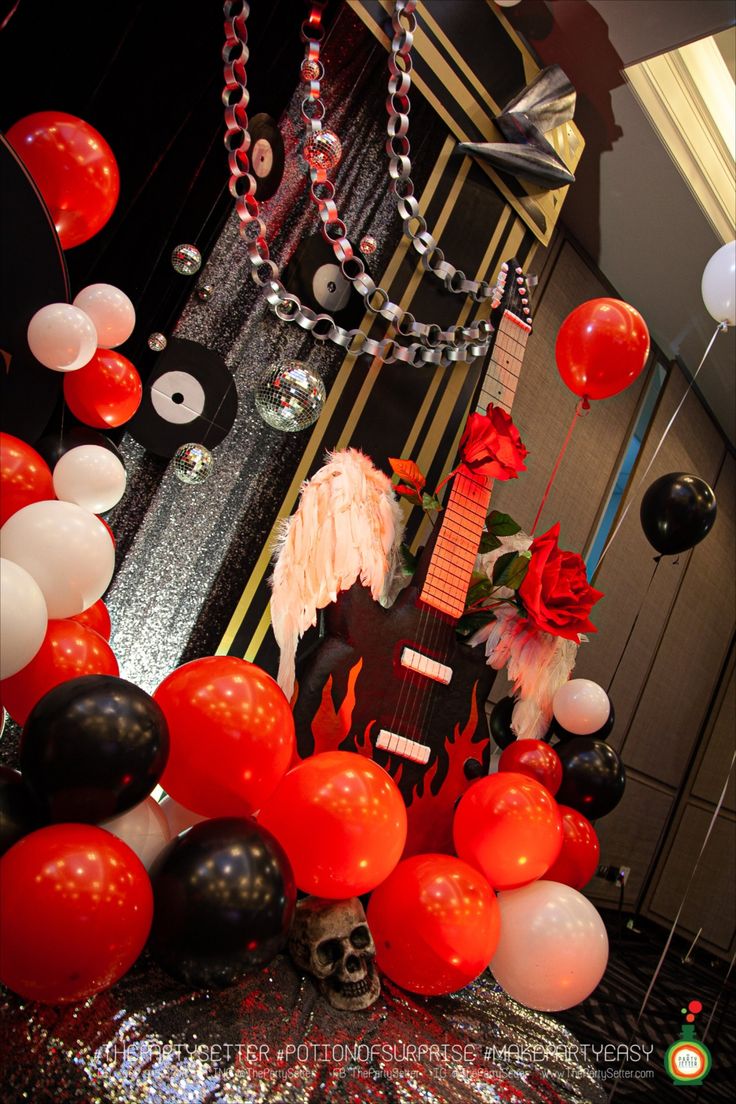 a room filled with balloons and decorations for a halloween themed party or birthday celebration in red, white and black