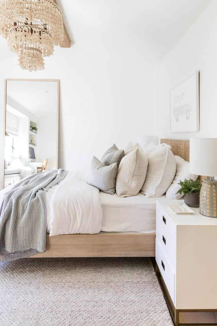 a bedroom with a bed, dresser and chandelier hanging from the ceiling above it