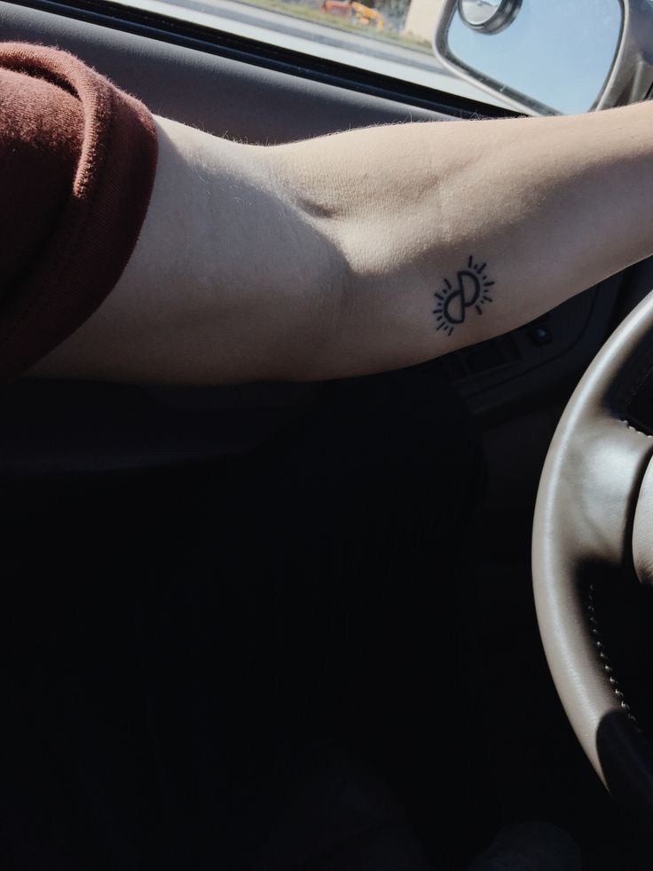 a person's arm with a sun tattoo on it