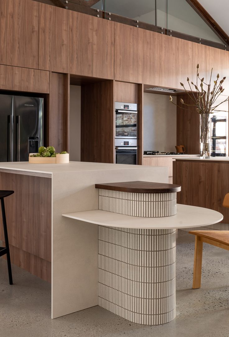 a modern kitchen with wooden cabinets and white counter tops, along with an island in the middle