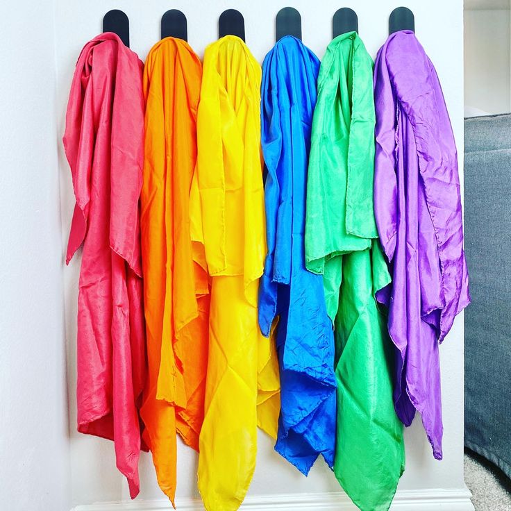 rainbow colored umbrellas are hanging on the wall