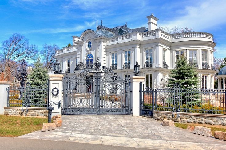 a large white mansion with an iron gate