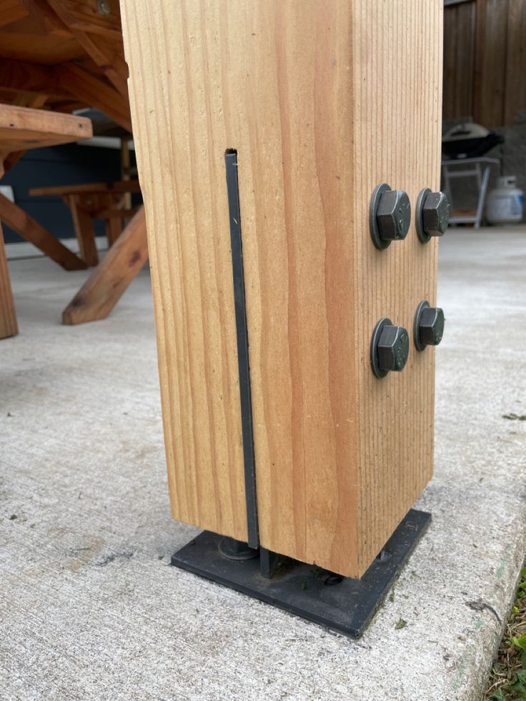 a wooden cabinet with four knobs on the front and back sides, sitting outside