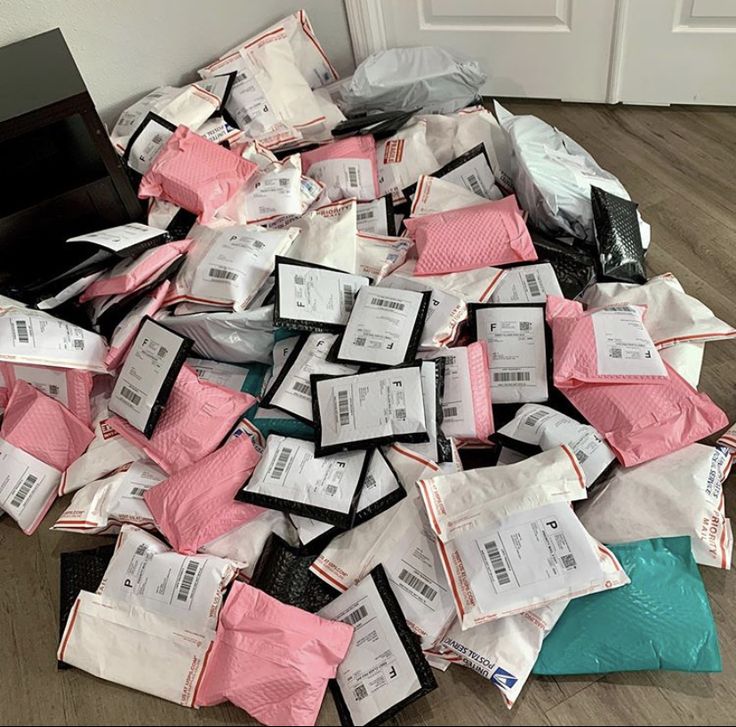 a pile of pink and white bags sitting on top of a wooden floor next to a door