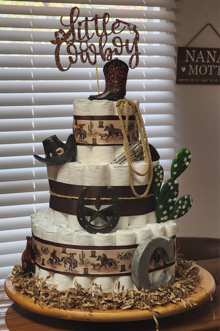 a three tiered cake with cowboy themed decorations