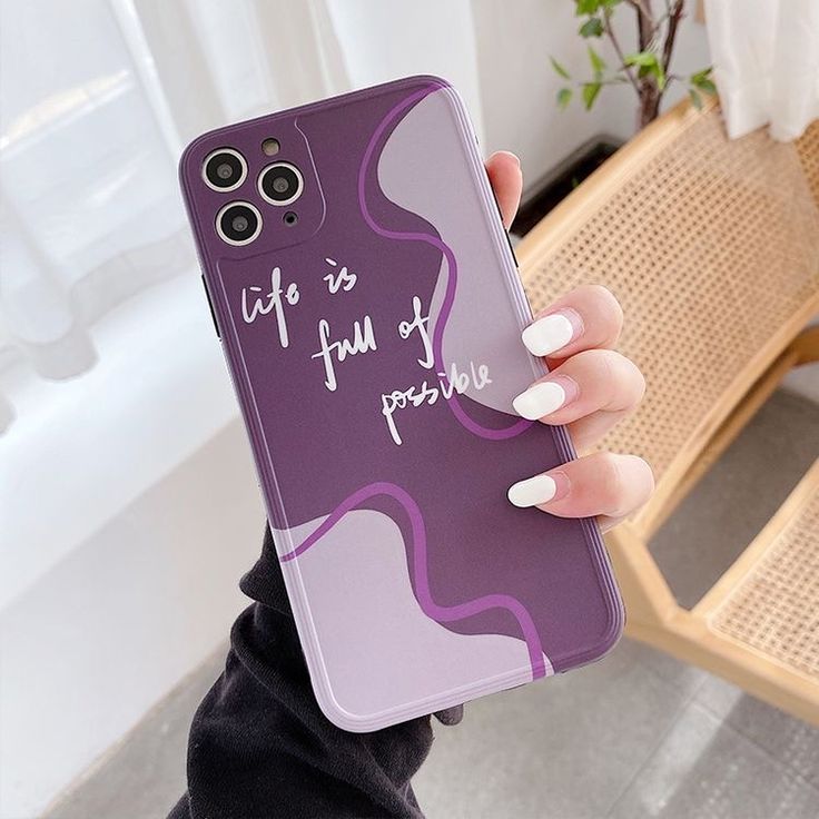 a woman holding up her phone case that says life is full of poopies