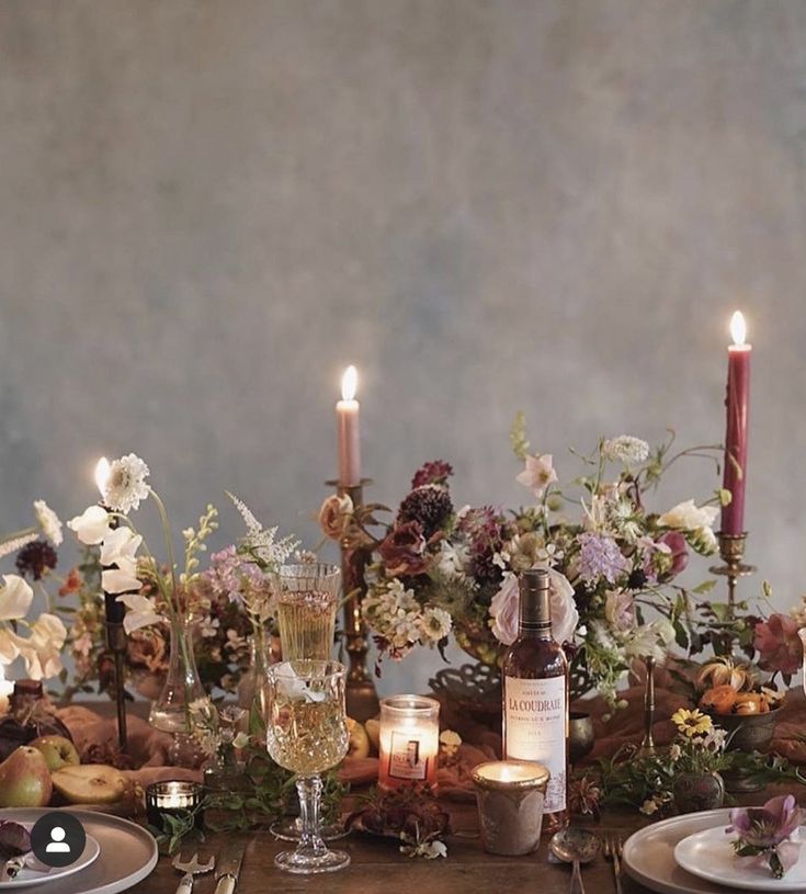 the table is set with flowers and candles