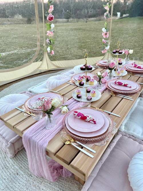 a table set up with pink plates and desserts