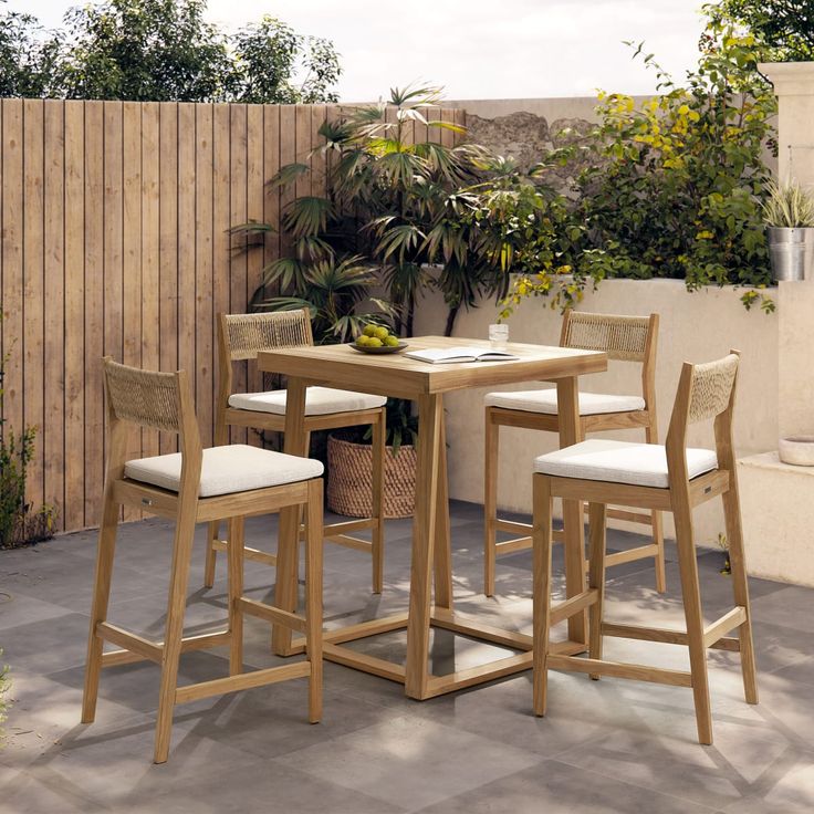 a wooden table with four stools next to a potted plant on a patio