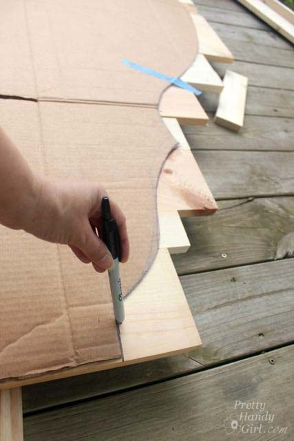 a person is using a tool to cut out the wood on top of a piece of cardboard