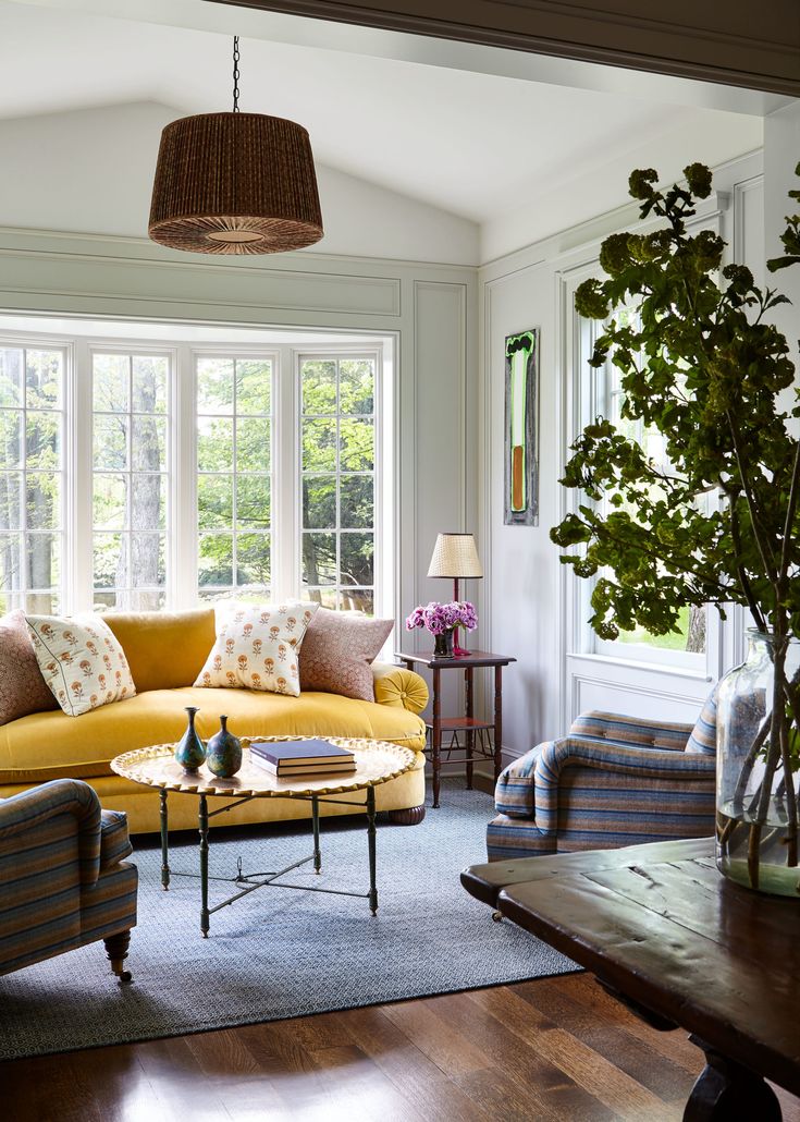 a living room filled with furniture and a potted plant on top of a table