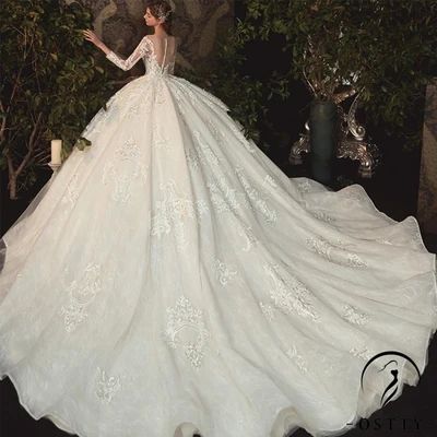 a woman in a white wedding dress standing next to some trees