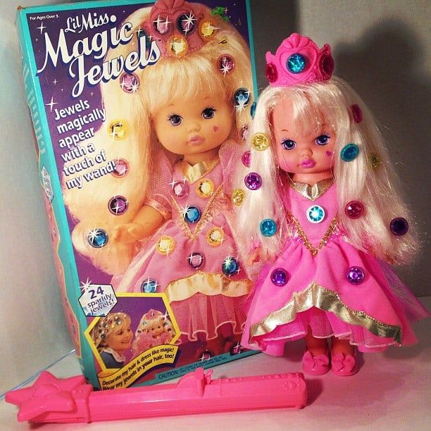 two dolls are standing next to each other in front of a magazine with the title'little miss magic jewels'on it